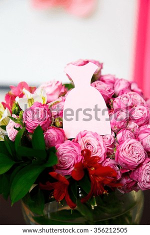 One card in the form of pink dress on bouquet of pink roses