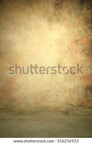 Painted canvas or muslin fabric cloth studio backdrop or background, suitable for use with portraits, products and concepts. Pink, peach, olive green, brown and ecru colors with lighter center spot. Royalty-Free Stock Photo #356256923