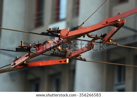 Trolleybus wire switch on the city background Royalty-Free Stock Photo #356266583