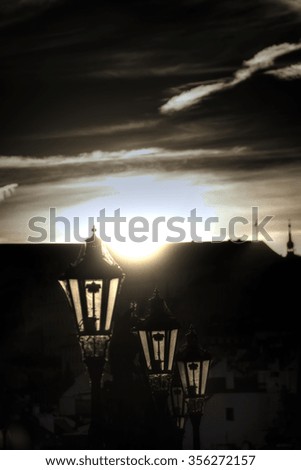 HDR image of old historic lamps on the Charles bridge with old buildings in the background and during a sunset
