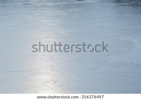 Frozen lake surface, natural abstraction of blue sky reflected in ice of frozen lake