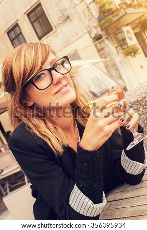 Girl drinking wine outdoors.