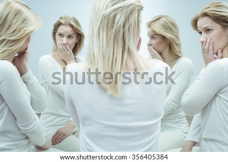 Young scared schizophrenic girl and her alter egos Royalty-Free Stock Photo #356405384