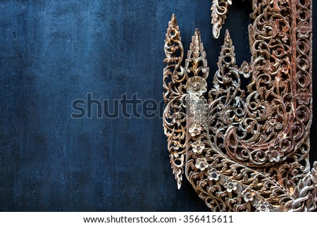 Thai wood carving of flowers on a black background