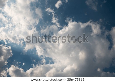 Sun beam with fluffy white clouds 