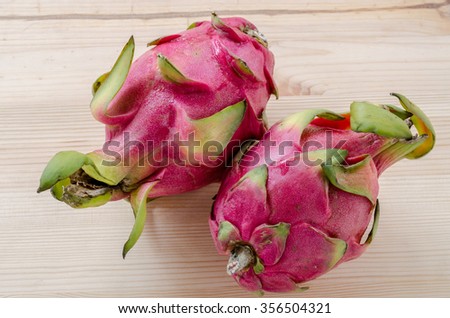 Fresh dragon fruits on wooden background.