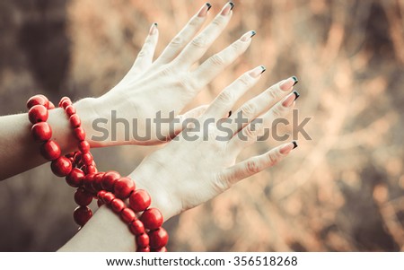 strand with red beads on hands,horizontal photo