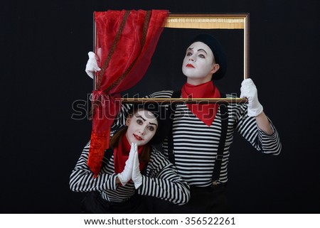 a guy and a girl in clown suits holding picture frame