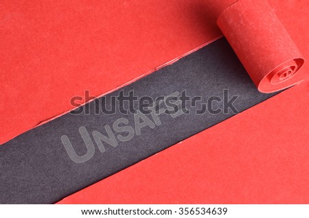 Unsafe word on top of blackboard and torn red paper