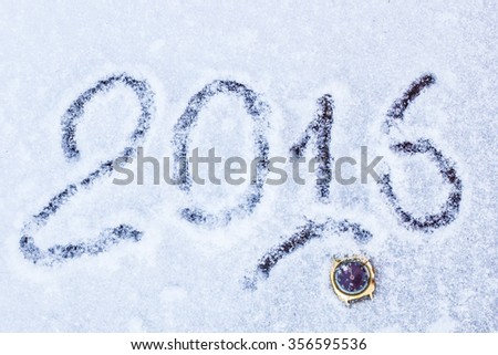 old watch lying in the snow in the 2016 New Year