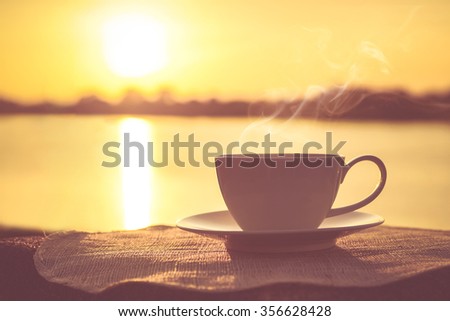 Silhouettes of sunrise morning coffee with a note and a pen Royalty-Free Stock Photo #356628428