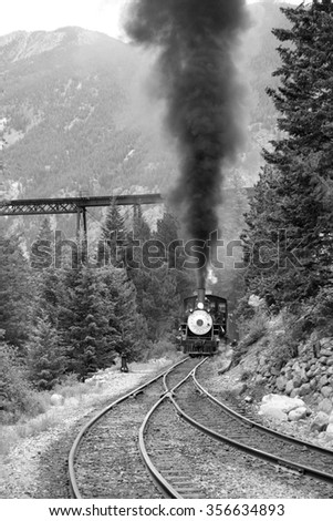 Steam train is coming up. Black and white photography.