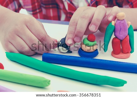 Close up child's hand creating toys from play dough. Strengthen the imagination of child. Child moulding whale modeling clay. Vintage picture style.