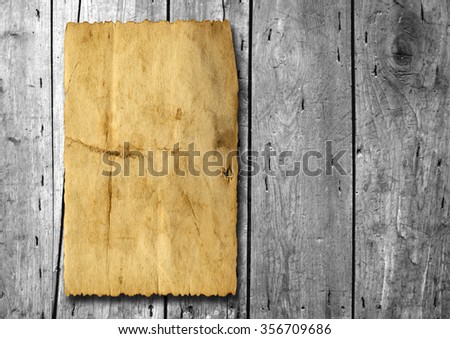 Vintage old grungy paper banner over ancient wood texture background metaphor for aged, retro, wooden, dirty, textured, manuscript, antique, parchment, book, ancient, weathered or grungy