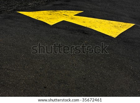 yellow arrow on black asphalt