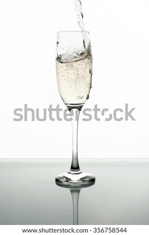 Photo of Pouring champagne into glass on white background
