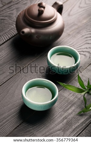 Asian clay teapot with glazed clay bowls for green tea