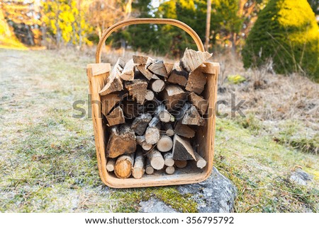 Firewood basket outside on frosty grass during winter. Sweden