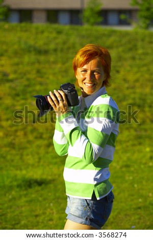  a woman in her twenties taking photo with a compact digital camera