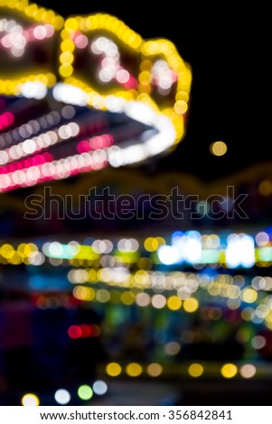Blurred lights of a fairground carousel against a black background