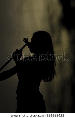 silhouette of a woman nosing to flower