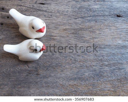 a pair of ceramic love birds  on wood for Valentine's day background