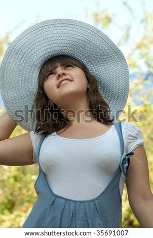 Young girl with hat is looking up