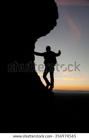 Tourists climbing silhouette at sunset for background.