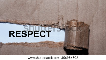 Torn paper box with word respect in low light