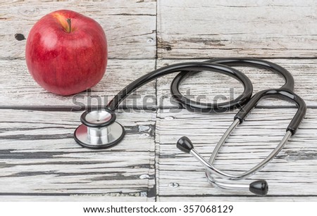 Medical stethoscope with an apple. Healthy lifestyle concept image.
