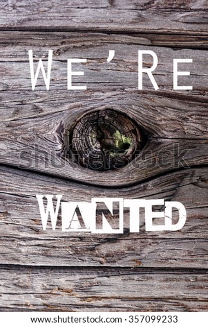 A word of "we're wanted" in the background of wood                                  