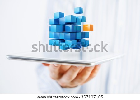 Businessman holding tablet and cube as symbol of problem solving 