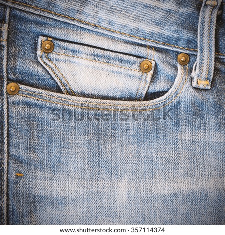 Detail of front pocket of faded blue jean pants