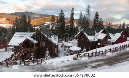 The wooden hut covered with fresh snow in the woods in the winter landscape in the Carpathian mountains , Bukovel , Ukraine. Horizontal photo