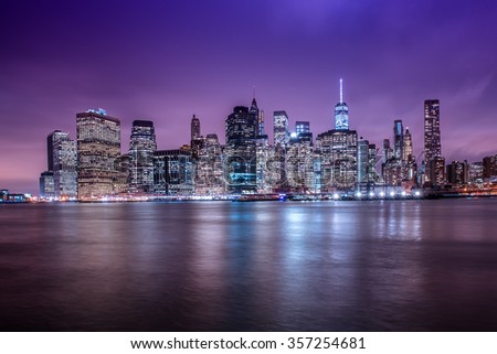 New York City Manhattan downtown skyline at dusk with skyscrapers illuminated over Hudson River panorama