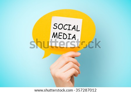Adhesive note on yellow speech bubble with "social media" words on blue background.
