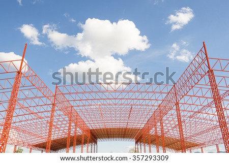 Structure building of Red Steel structure roof truss under the new factory of building at construction site with blue sky