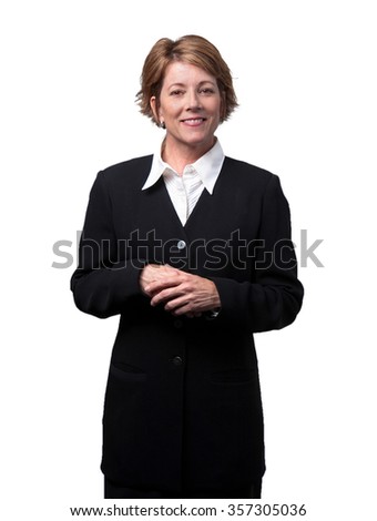 Happy contented business woman in black suite with a white shirt, standing with hands in front, smiling on white background