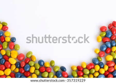 chocolate smarties shaping lower part of picture on white with copy space