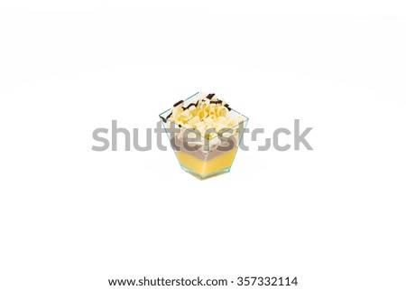 In the picture a cupcake with white chocolate,cream and custard in a plastic cup, isolated on white background.
