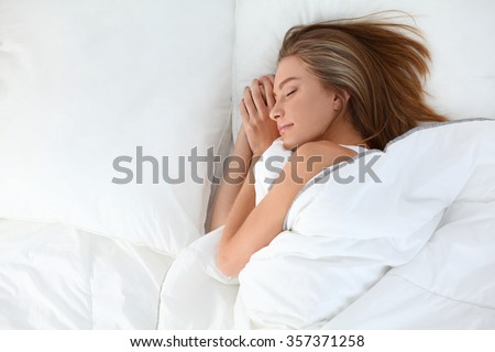 Beautiful girl sleeps in the bedroom Royalty-Free Stock Photo #357371258