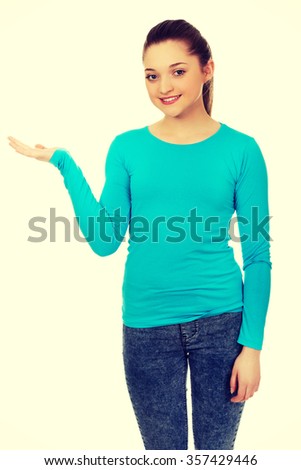 Teenage woman showing something on open hand.