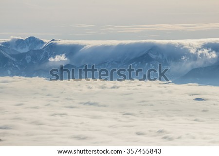 Fantastic winter morning landscape: above the clouds in the snowy mountains.  Dramatic beautiful sky. Creative collage.