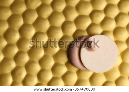 Makeup sponge with liquid foundation on abstract background