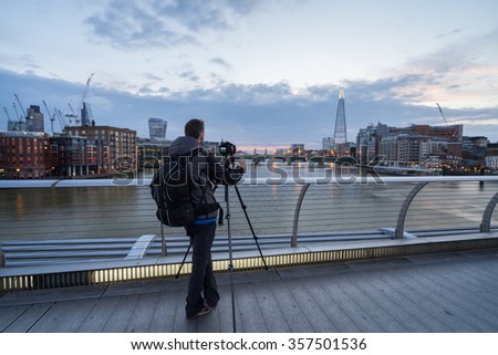 Cityscape photographer taking picture of London panorama at sunrise from Millennium bridge