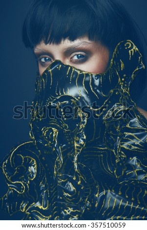 Portrait of young female model in creative mask 