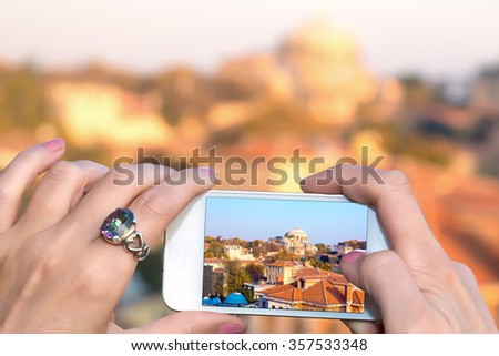 Me taking Photo with camera phone in Istanbul city female hands holding white telephone with Picture of famous attraction view
