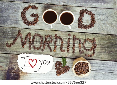 good morning concept - coffee beans, Cup of black coffee, heart from coffee beans, coffee leaves. paper sticker lovely message  - i love you.  Toned, selective focus image. 