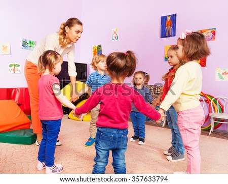Teacher and group of kids in kindergarten  Royalty-Free Stock Photo #357633794