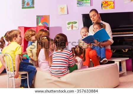Nurse in kindergarten read book to the class Royalty-Free Stock Photo #357633884